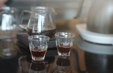 The drip coffee is ready to be served in a cup on the table.