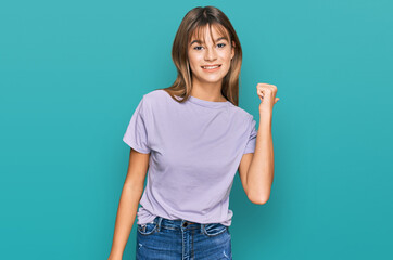 Teenager caucasian girl wearing casual clothes smiling with happy face looking and pointing to the side with thumb up.