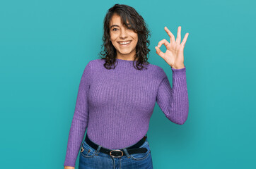 Fototapeta na wymiar Young hispanic woman wearing casual clothes smiling positive doing ok sign with hand and fingers. successful expression.