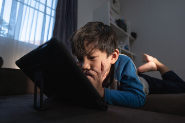 Fototapeta premium Asian boy watching computer tablet.