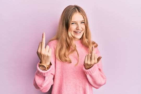Beautiful young caucasian girl wearing casual clothes showing middle finger doing fuck you bad expression, provocation and rude attitude. screaming excited
