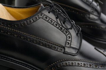 Black brogue derby shoes on cedar shoe-tree close up