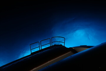 super yacht at night with blue underwater lights 