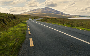 Beautiful scenery of road by the lough inagh with mountains in the background at Connemara National...
