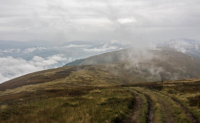 Fototapeta na wymiar highland mountain meadows with mist and clouds