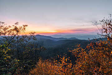 A small break in the color fall foliage reveals the blue layers of the Blue Ridge Mountains during...