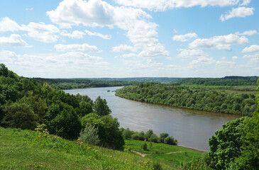 Fototapeta na wymiar A picturesque view of the bend of the Oka River from a high wooded hill. Windy, sunny summer day.