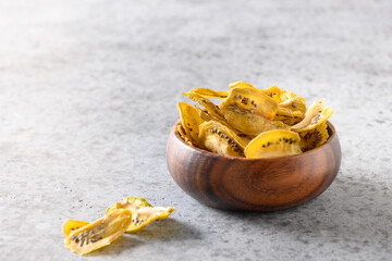Sliced fresh and dried fruits kiwi chips on grey stone background, home drying. Snack vegan free...