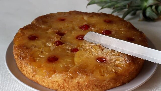 Carefully slicing the pineapple upside down cake