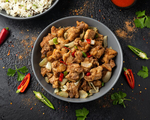 Stir fry chinese salt and pepper chicken with rice in grey bowl