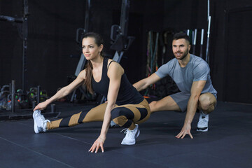 Fototapeta na wymiar Portrait of a muscular couple doing leg stretchings