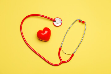 Red heart with stethoscope on color background
