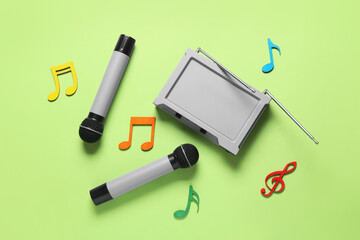 Modern microphones with audio system and music notes on color background