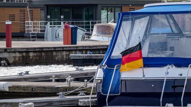 Teilansicht eines Bootsheck im Hafen mit deutscher Flagge im Wind