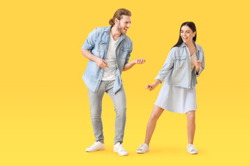 Obraz premium Happy young couple dancing on color background