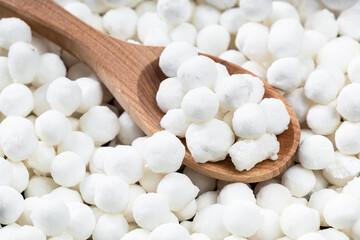 above view of wooden spoon with raw tapioca pearls