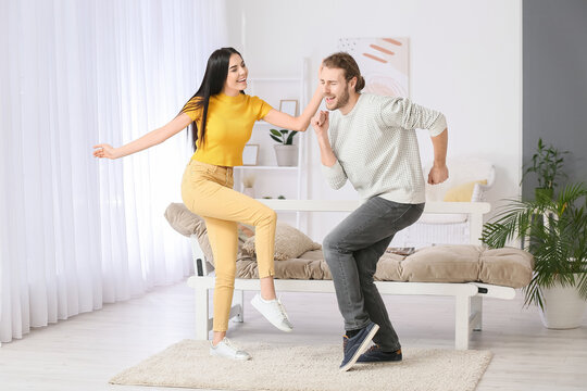 Happy Young Couple Dancing At Home