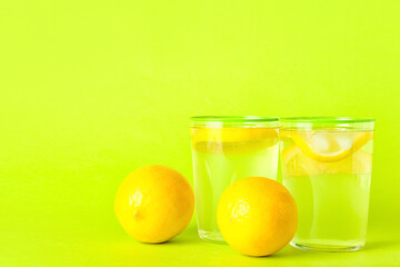 Glasses of tasty cold lemonade on color background