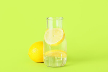 Bottle of tasty cold lemonade on color background