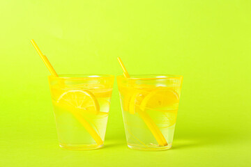 Glasses of tasty cold lemonade on color background