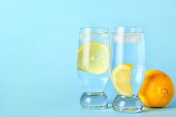 Glasses of tasty cold lemonade on color background
