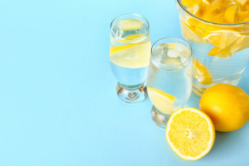 Jar and glasses of tasty cold lemonade on color background