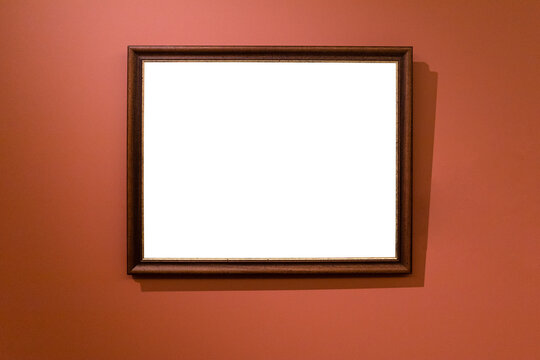 narrow brown wooden picture frame on dark red wall