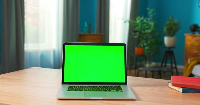 Laptop With Green Mock Up Screen On A Desk In A Cozy Living Room At Home.