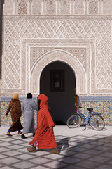 women in colorful hidzab on the street next to incredible carved exteriors of amazing peaces of...
