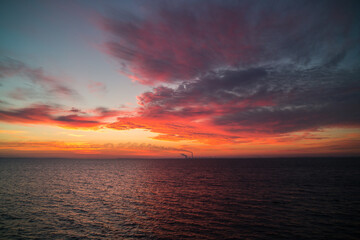 Naklejka na ściany i meble beautiful sunrise and sunset near the sea. a place to relax by the sea. orange sky near water