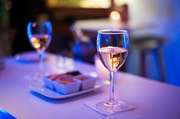 two glasses with pink champagne vine with small delicious appetizer in a high-class reception 