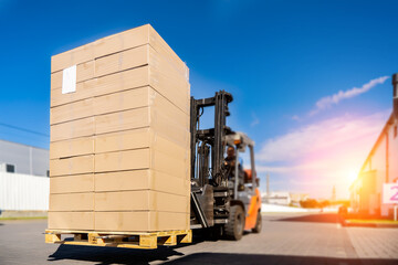 Forklift vehicle manipulating goods in logistic area outside warehouse.