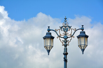 Fototapeta na wymiar Old style street lamps against a cloudy sky