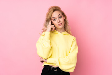 Young blonde woman wearing a sweatshirt isolated on pink background thinking an idea