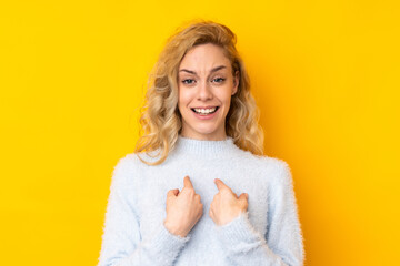 Young blonde woman isolated on yellow background with surprise facial expression