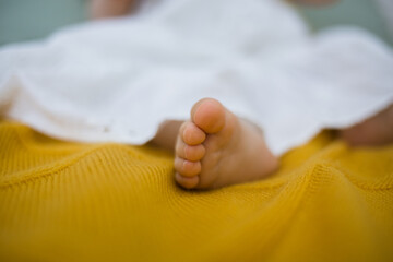 close-up of a child's small toes on a yellow wool blanket