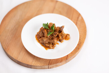 Beef stroganoff garnished with parsley on a white background