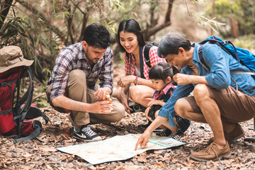 A group of young Asians are planning and looking at maps for camping in the forest.Asian and...