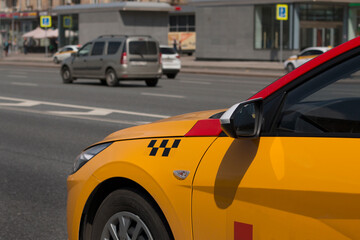 Yellow taxi with checker pattern, close-up view. Yellow taxi cab on the street of downtown