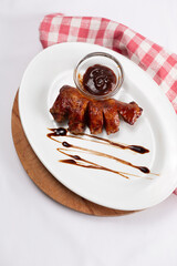 Grilled meat with barbecue sauce on white plate
