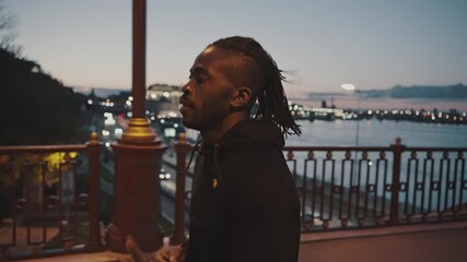 Close up outdoor portrait of active african american guy practicing evening jog workout, training alone on city bridge