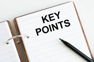 key points, text on white notepad on white background near black marker