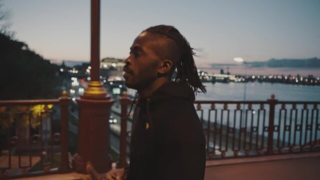 Close up outdoor portrait of active african american guy practicing evening jog workout, training alone on city bridge