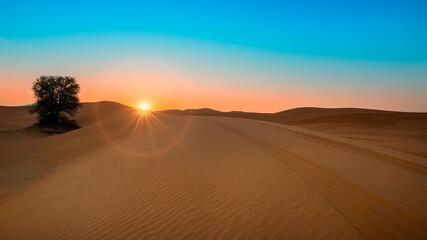 Beautiful Sunrise at desert including sand pattern with sun and shine and sun ring.