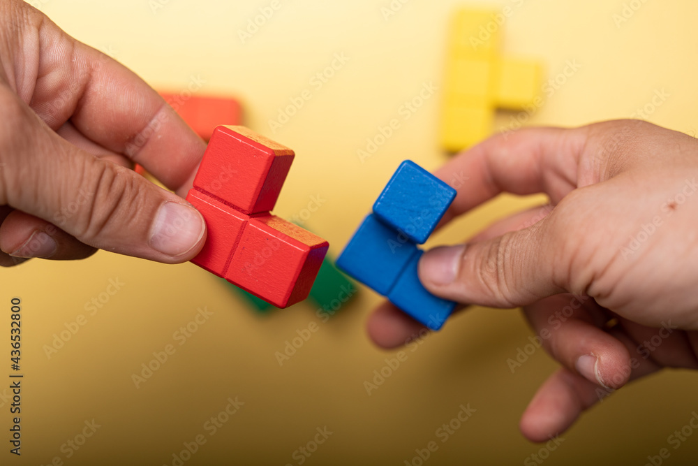 Poster hand holding piece of wooden block puzzle. wood cube stacking. concept of complex and smart logical 