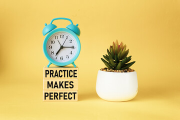 practice makes perfect - Motivational Reminder on Wooden Blocks and Yellow Background