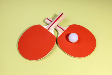 rackets and a table tennis ball on a green background