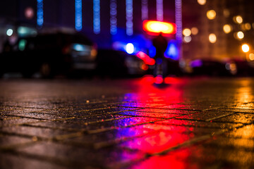 Rainy night in the big city, figure of a man on a background of light from the shop windows...