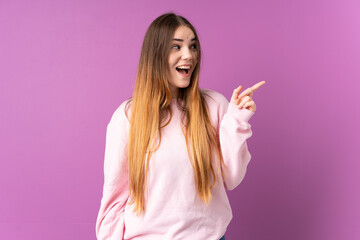 Young caucasian woman isolated on purple background intending to realizes the solution while lifting a finger up