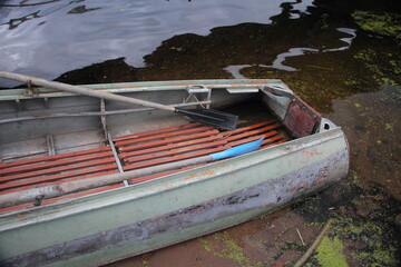 Empty abandoned old russian alloy rowing motor boat without outboard motor and without people on...